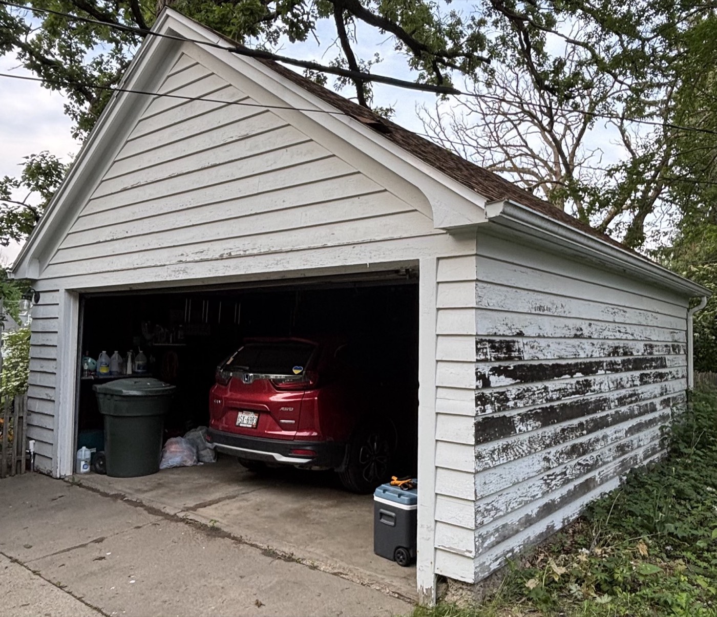 Garage exterior with badly peeling paint before any work begins