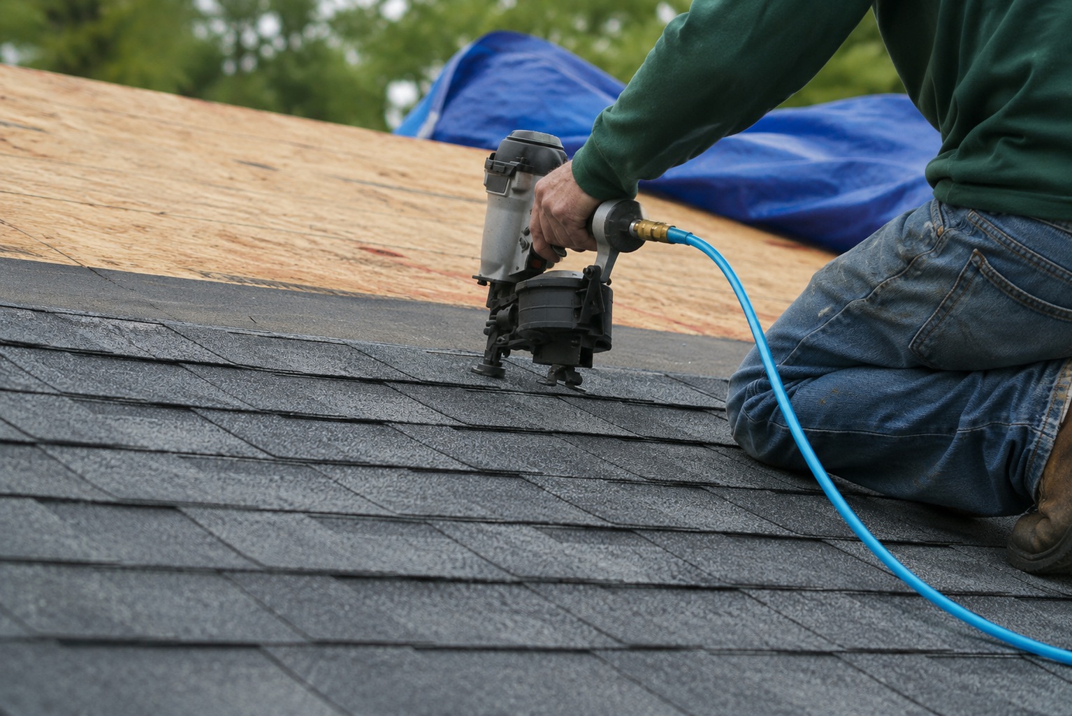 Roofer repairing shingles on a residential roof in Wisconsin